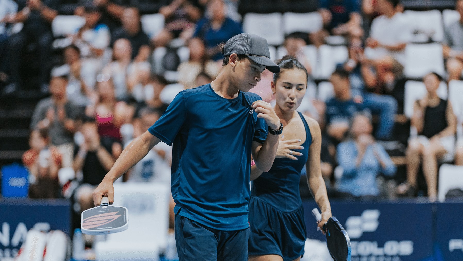 Mixed doubles pair between points at the PPA Tour Asia Hong Kong Slam, October 2026, with a crowd in the stands